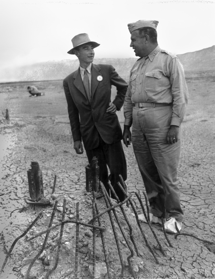 Robert Oppenheimer and General Groves at Trinity Test Ground Zero, 1945. The white canvas overshoes were to prevent fallout from sticking to the soles of their shoes.